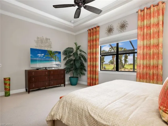 Primary Bedroom with Tray Ceiling, Crown Molding, Ceiling Fan, Custom Window Curtains,  Battery Powered Motorized Blackout Shade, & Golf Course View of 17th Hole