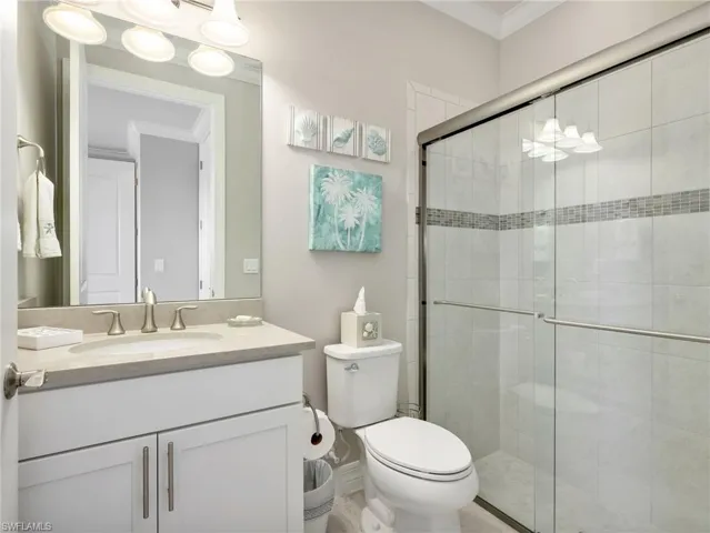 Front Guest Room En-Suite Bathroom with White Shaker Vanity with Quartz Counter, & Walk-In Tile Shower with Glass Sliding Door Enclosure