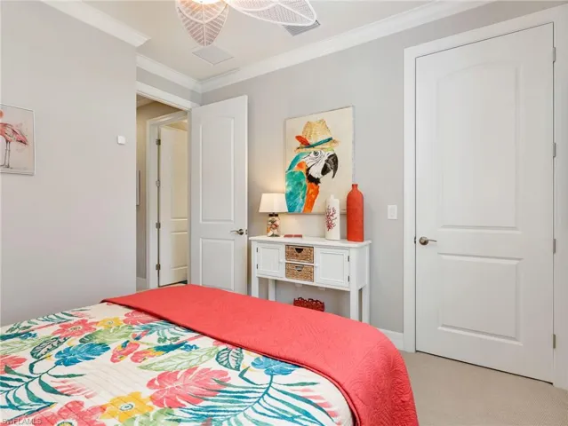 Middle Guest Bedroom with Crown Molding, Ceiling Fan, & Large Walk-In Closet