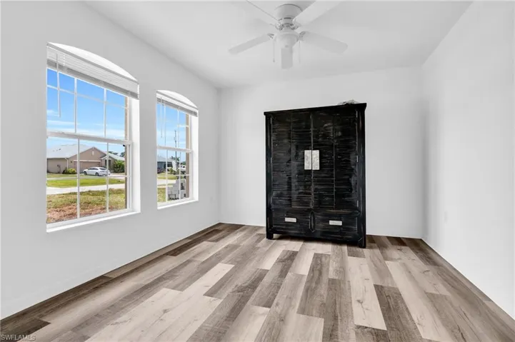 Unfurnished room with baseboards, ceiling fan, and wood finished floors