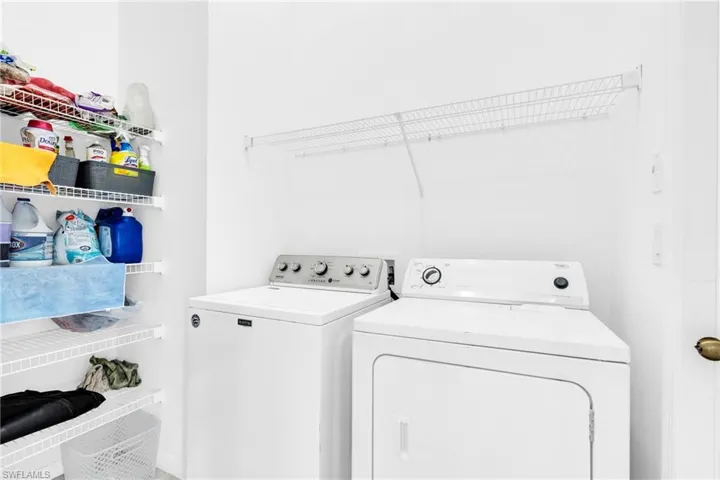 Washroom with laundry area and washing machine and clothes dryer