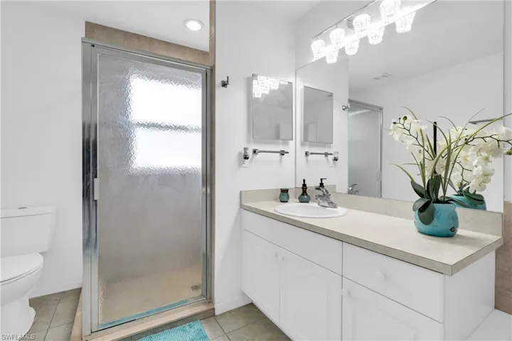 Bathroom featuring visible vents, a shower stall, vanity, tile patterned floors, and toilet