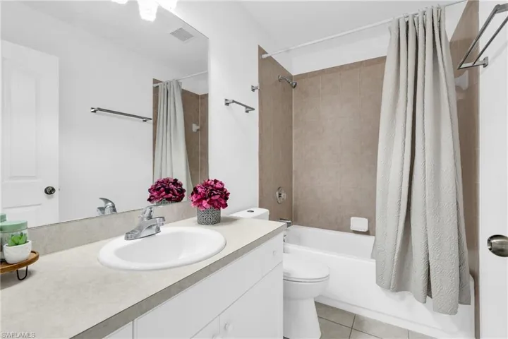 Bathroom with visible vents, vanity, toilet, tile patterned floors, and shower / bath combo