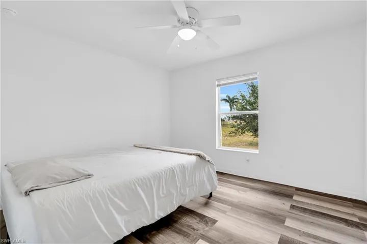 Bedroom with baseboards, ceiling fan, and wood finished floors
