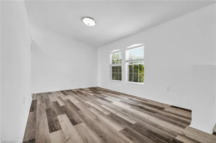 Spare room featuring baseboards and wood finished floors