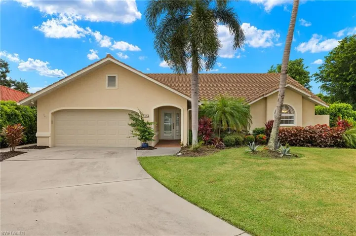 Mediterranean / spanish home with a front yard, concrete driveway, stucco siding, and an attached garage