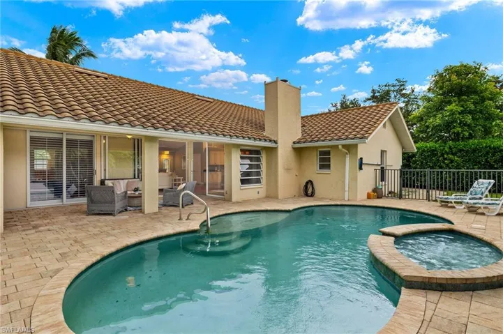 View of pool with a patio, fence, a pool with connected hot tub, and outdoor lounge area