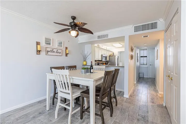 Dining area with ceiling fan, light hardwood / wood-style flooring, and ornamental molding