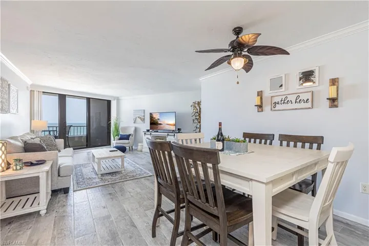 Dining area with wood-type flooring, crown molding, and ceiling fan