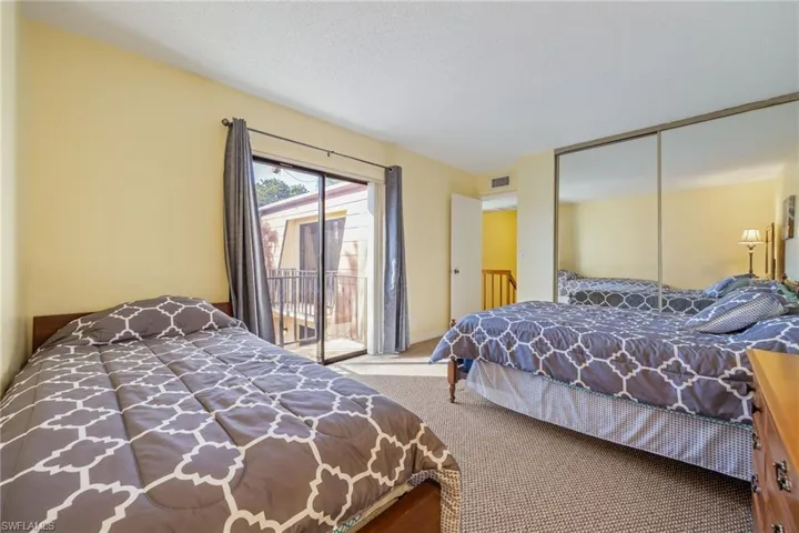 Bedroom featuring access to outside, carpet flooring, and a closet