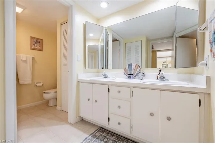 Full bathroom with a closet, double vanity, recessed lighting, and light tile patterned floors