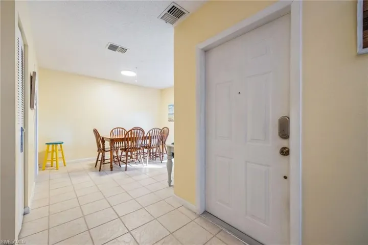 Entryway featuring light tile patterned flooring and a textured ceiling