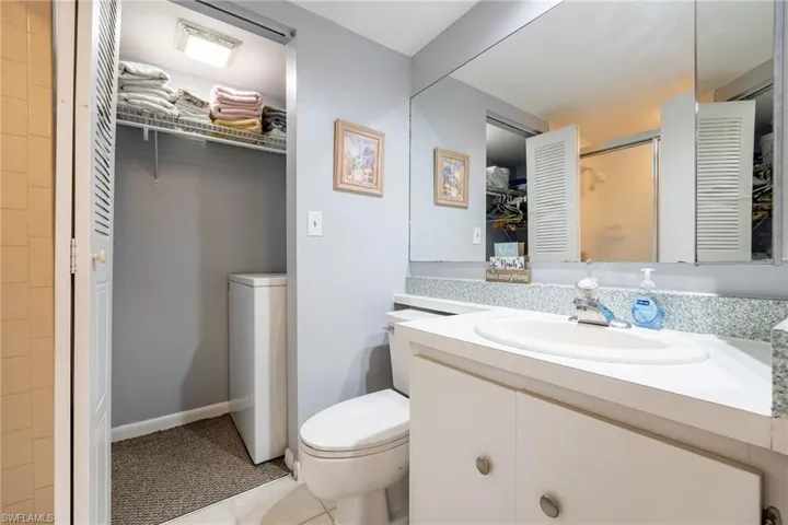 Full bathroom with vanity, washer / dryer, and light tile patterned flooring