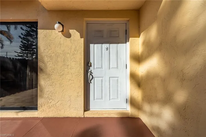Doorway to property featuring stucco siding