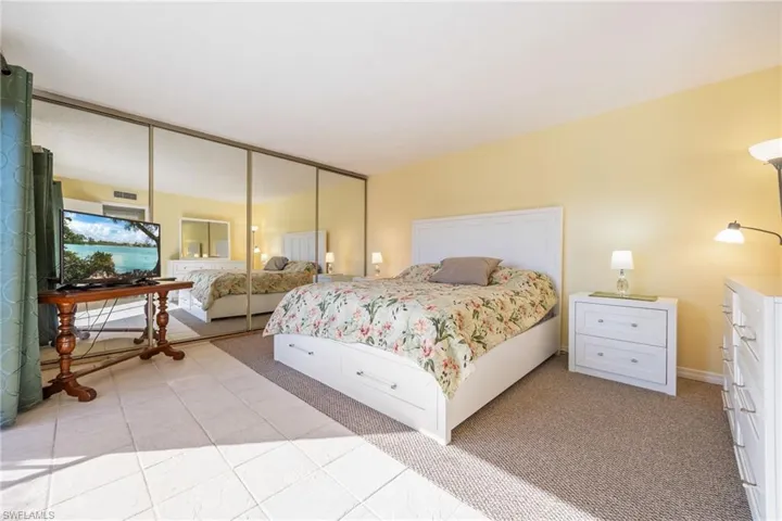 Bedroom featuring light carpet, a closet, and light tile patterned floors