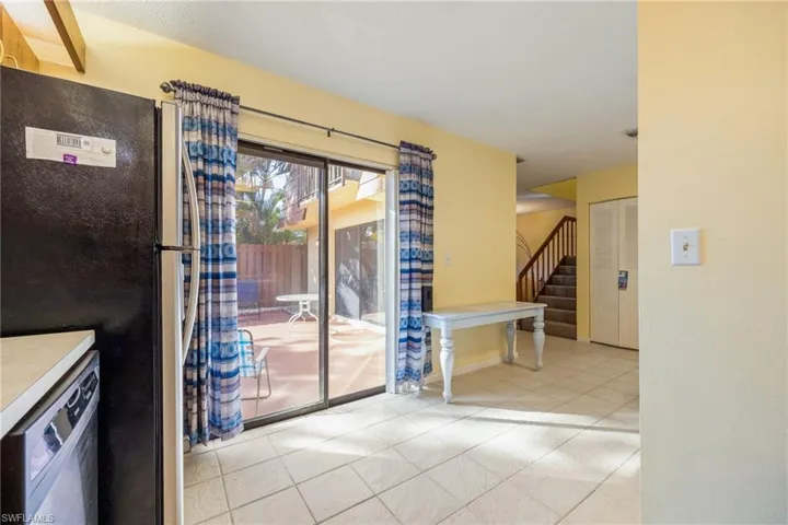 Unfurnished dining area with stairway and light tile patterned flooring