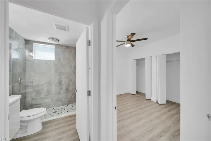 Bathroom with grey tile shower, pebble tile shower floor, and a window