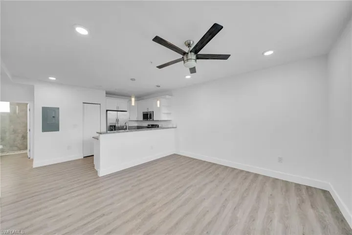 Open-concept living area featuring wood-finish flooring, recessed lighting, and a ceiling fan