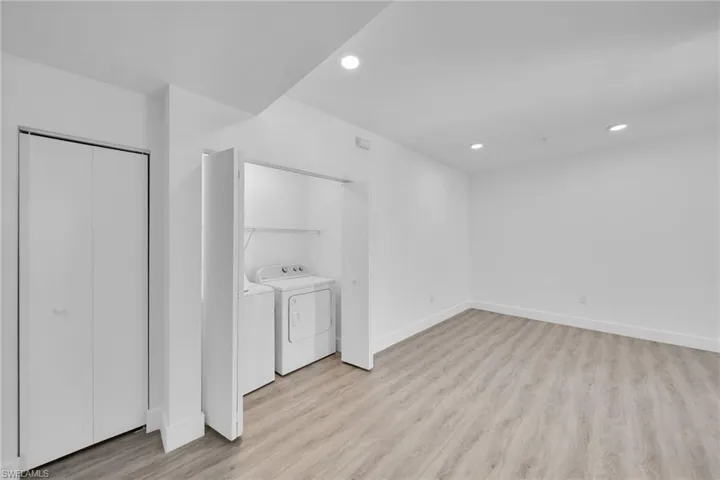 Recessed lighting, wood-finish flooring, washer and dryer appliances, and a built-in closet with bifold doors