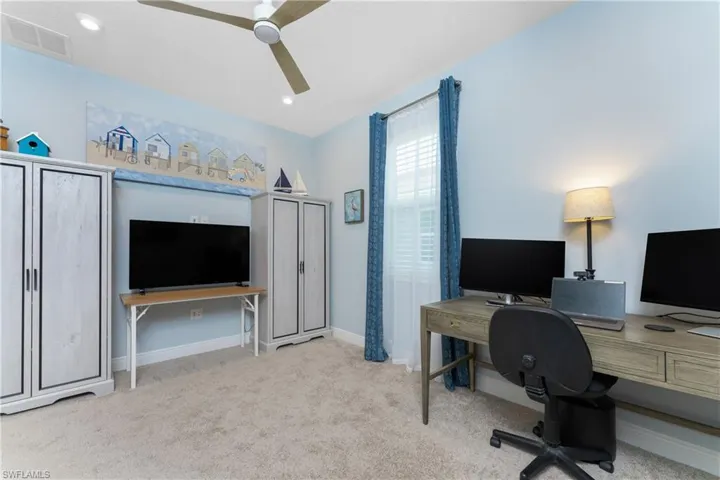 Office with vaulted ceiling, ceiling fan, and light colored carpet