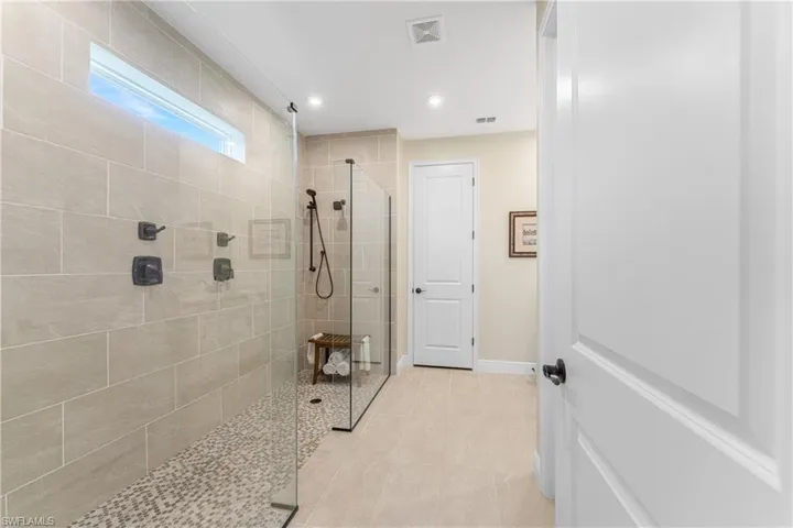 Bathroom with tile patterned flooring and tiled shower