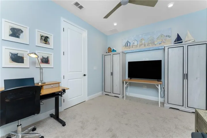 Office space with light carpet and ceiling fan