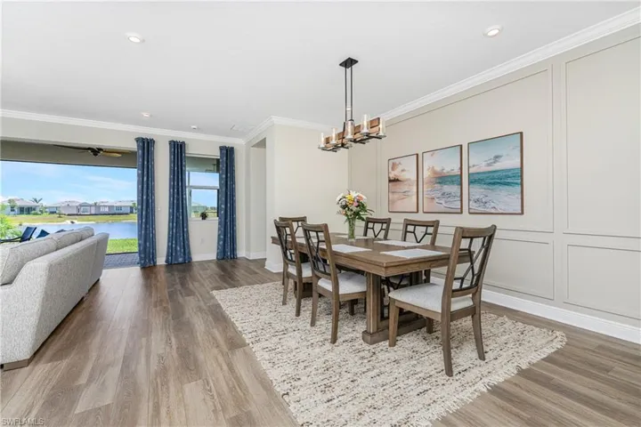 Dining space featuring hardwood / wood-style flooring, a chandelier, and ornamental molding