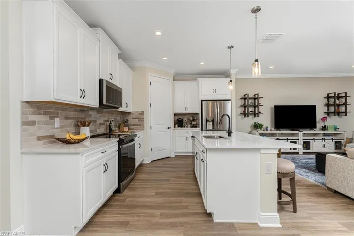 Kitchen featuring hanging light fixtures, sink, a kitchen island with sink, appliances with stainless steel finishes, and light hardwood / wood-style floors