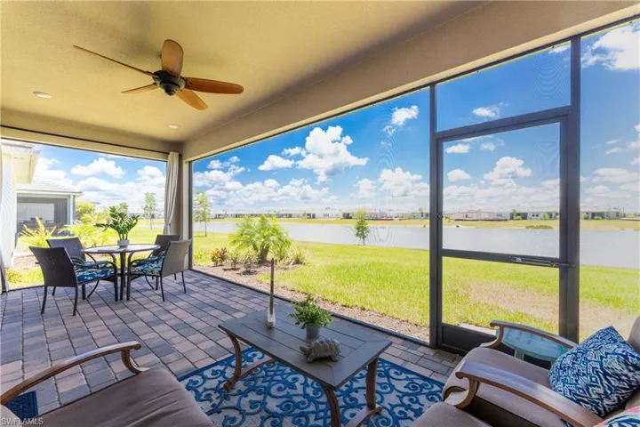 Sunroom / solarium featuring a water view and ceiling fan