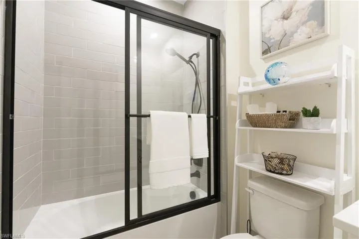 Bathroom with enclosed tub / shower combo and toilet
