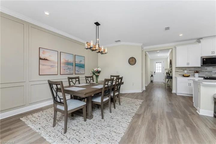Dining area featuring crown molding, light hardwood / wood-style floors, and a chandelier