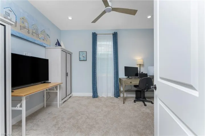 Carpeted office space featuring ceiling fan