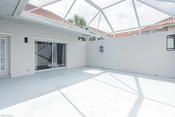 View of patio featuring a sunroom and glass enclosure