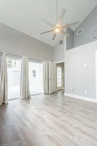 Unfurnished room featuring high vaulted ceiling, light wood finished floors, and ceiling fan