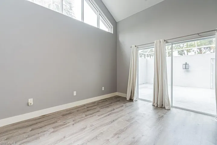 Empty room featuring light wood-style floors and high vaulted ceiling