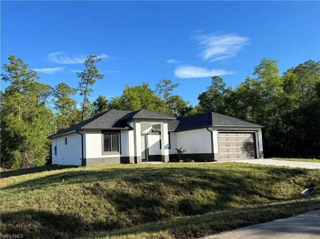 View of front of home featuring a garage and a front lawn
