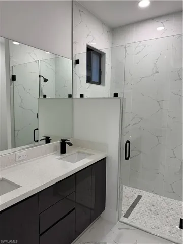 Bathroom featuring vanity and an enclosed shower