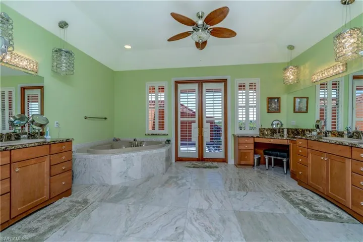 Master bathroom upstairs with double vanities, sinks, jetted tub, rain shower, specialty crystal lighting, Onxy flooring, ceiling fans and balcony