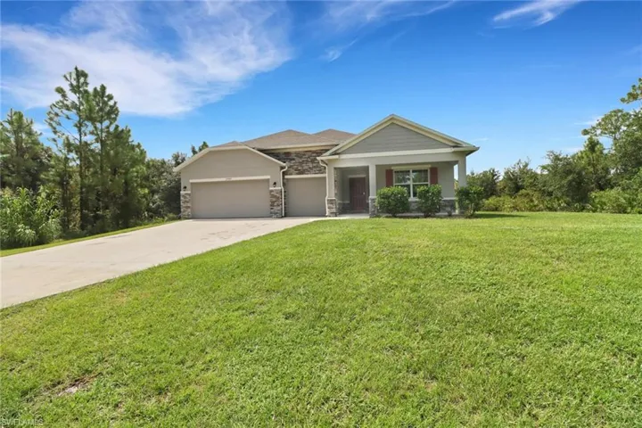 View of front of house with a garage and a front lawn