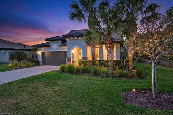 Mediterranean / spanish house with a tiled roof, stucco siding, a lawn, decorative driveway, and an attached garage