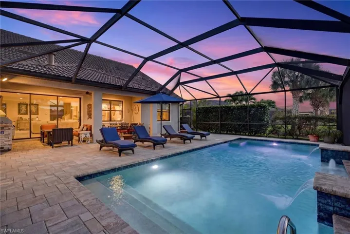 Swimming pool featuring a sunroom, glass enclosure, and a patio
