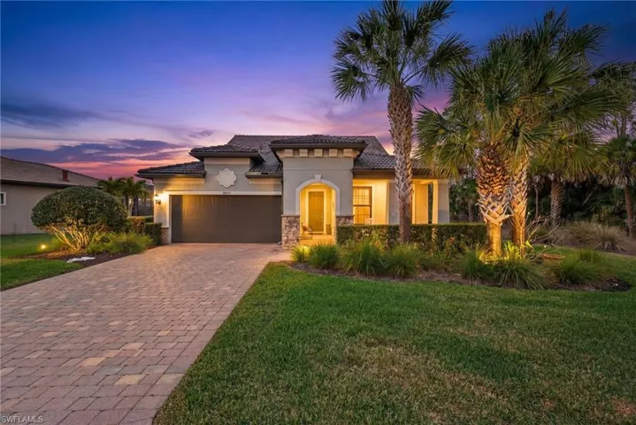 Mediterranean / spanish-style house with a garage, a tile roof, stucco siding, a yard, and decorative driveway