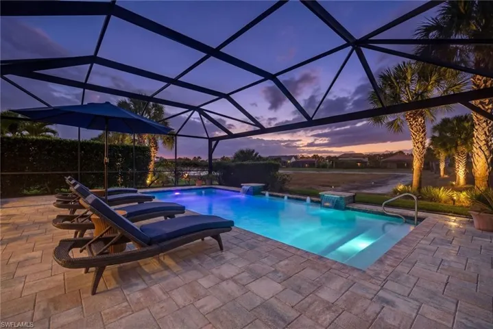 Pool at dusk with an outdoor pool, a lanai, and a patio