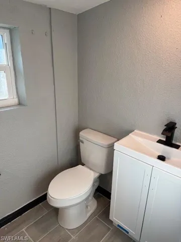 Bathroom with wood-type flooring, vanity, and toilet