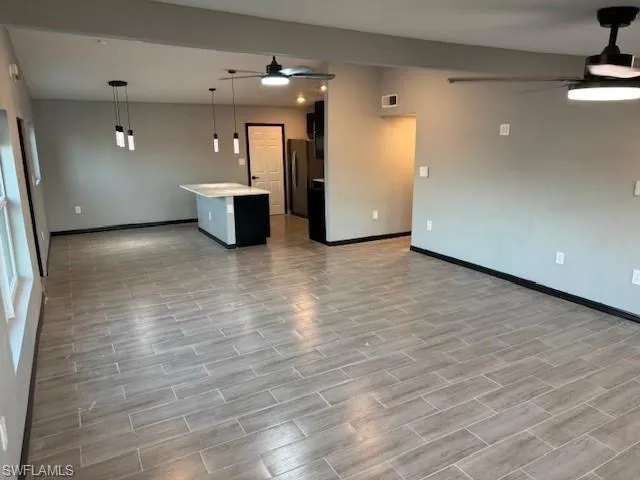 Unfurnished living room with ceiling fan and light hardwood / wood-style floors