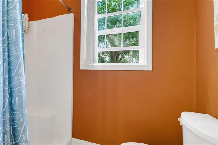 Bathroom with curtained shower and toilet