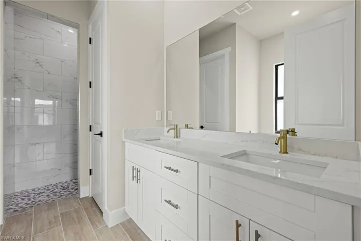 Master bathroom featuring double vanity, upgraded white quartz countertops, separate shower, tub and toilet areas.