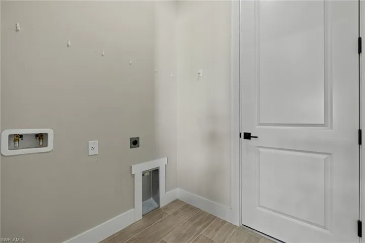 Washroom with light hardwood / wood-style floors, electric dryer and washer hookup