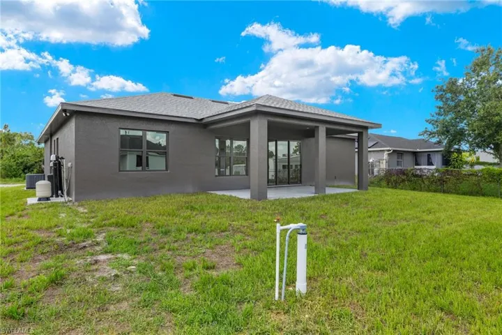 Rear view of house featuring a patio and a yard