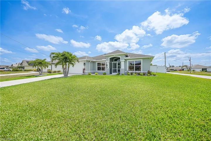 View of front of home featuring concrete driveway, an attached garage, stucco siding, and a front yard